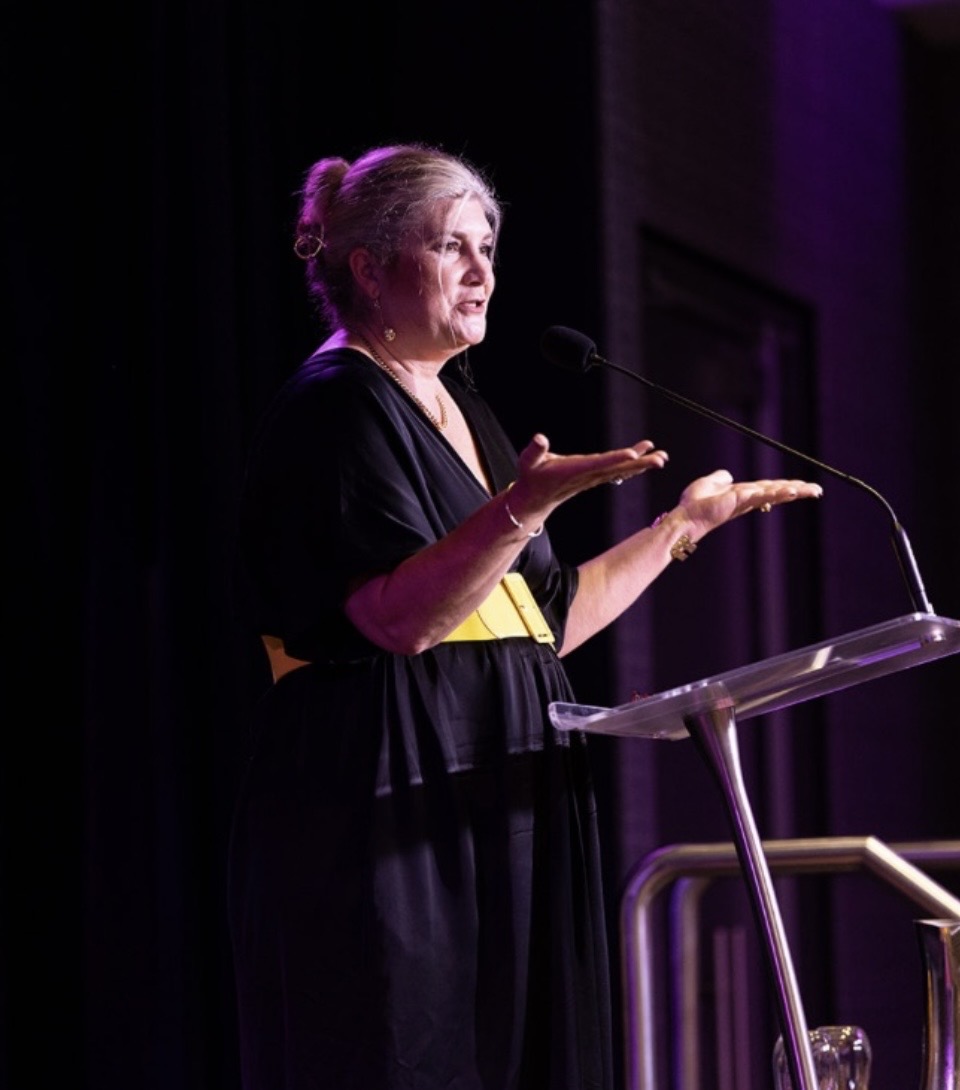 Dr Gabrielle Morrissey gesturing at a lectern during a keynote address