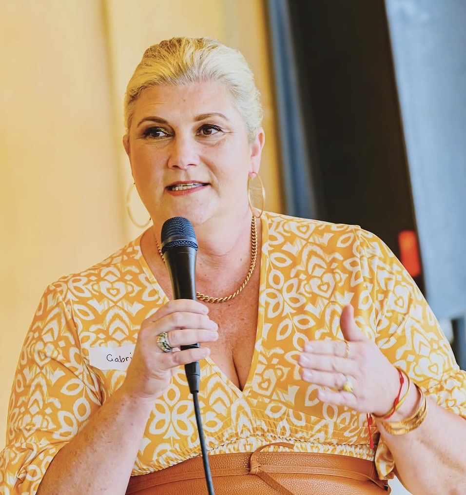 Dr Gabrielle Morrissey speaking into a handheld microphone at a live event
