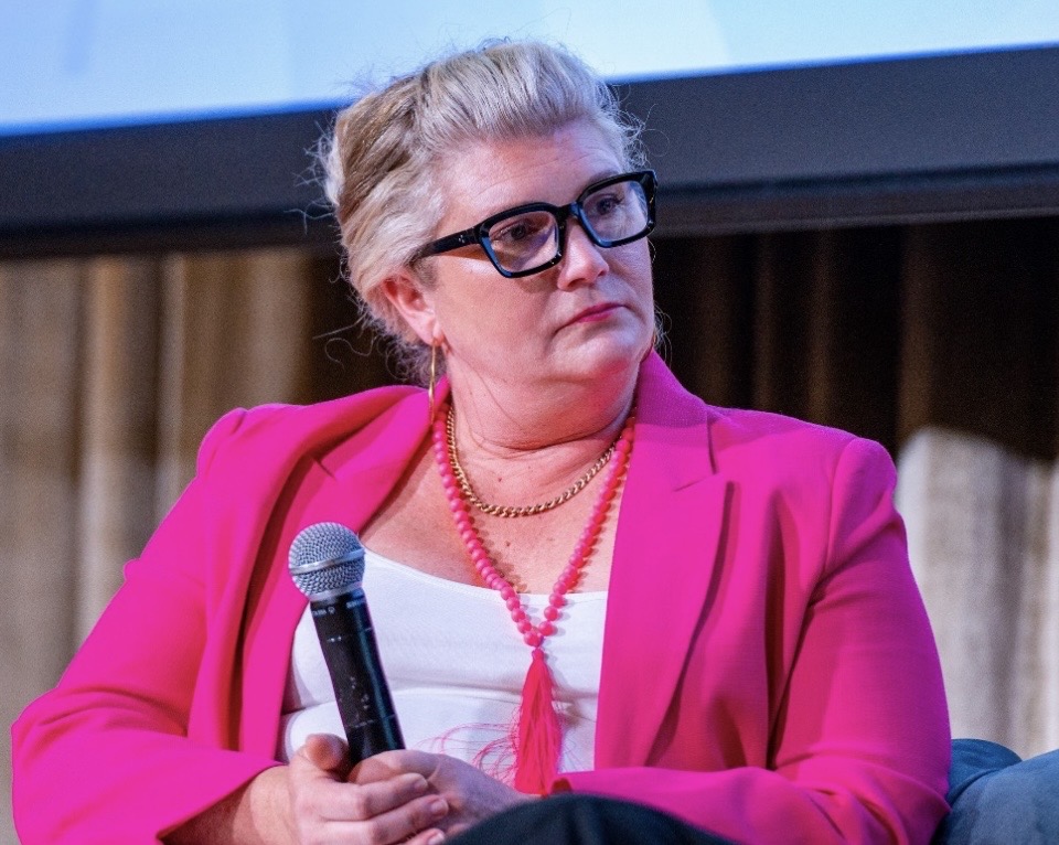 Dr Gabrielle Morrissey holding a microphone during a panel discussion